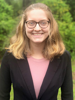 photograph of young woman wearing glasses and a suit