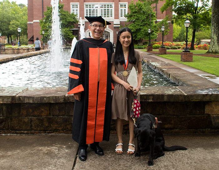 From left: Hendrix College President William M. Tsutsui, Kirin "Sai" Techawongtham, and Sai's guide dog, Luther.